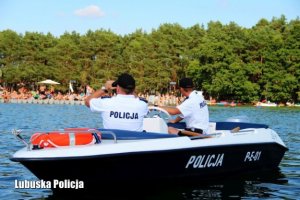 policjanci w mundurach na łodzi służbowej