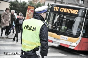 policjant w kamizelce i autobus