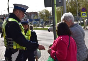 policjanci ruchu drogowego przekazują odblaski kobietom